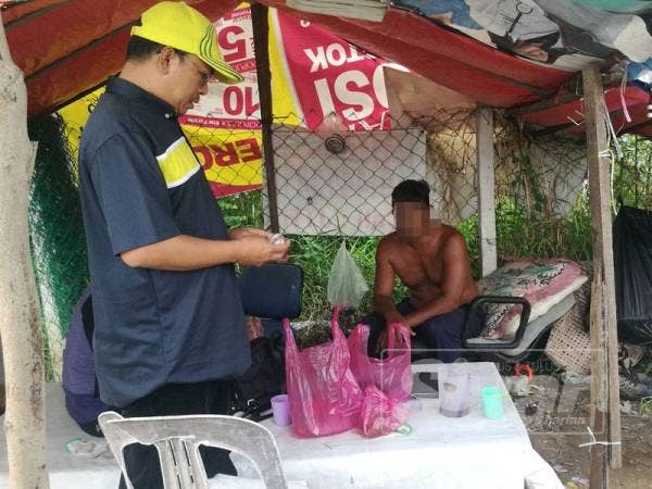 Syeikh Azhari (kiri) sedang menyoal seorang lelaki dalam serbuan di sebuah pondok di Lorong Titi Siam, di sini, hari ini.