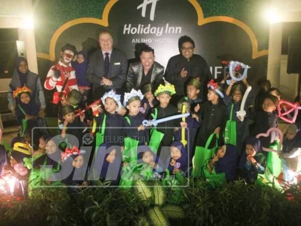 Aznil (tengah) bersama anak-anak yatim pada majlis pelancaran bufet Ramadan hotel tersebut baru-baru ini.