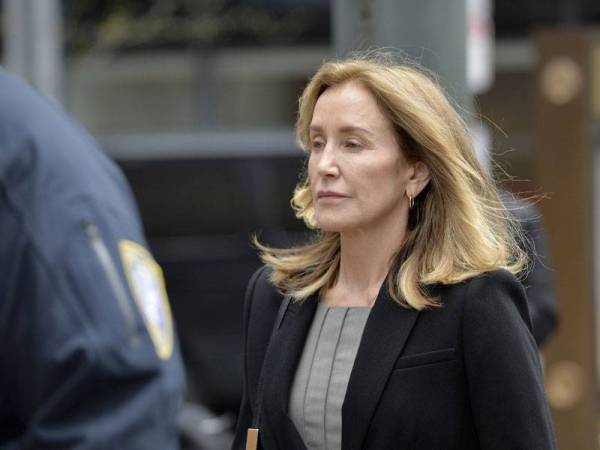 Felicity Huffman diiringi polis ketika memasuki perkarangan sebuah mahkamah di Boston semalam. - FOTO AFP