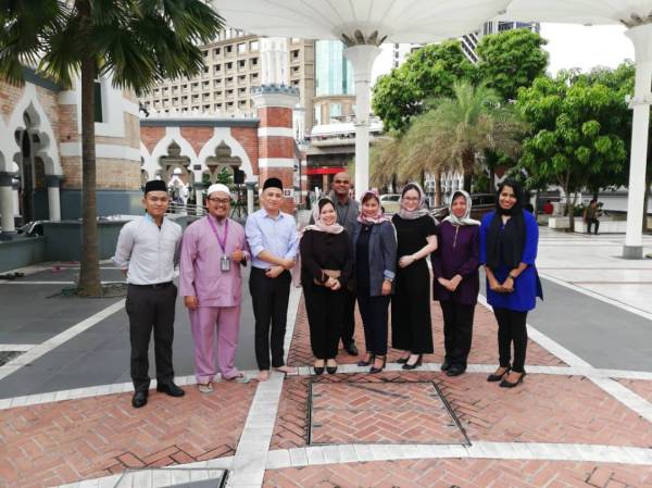 Susan (depan, empat dari kanan) bersama kakitangannya dan wakil pengurusan Masjid Jamek Sultan Abdul Samad bekerjasama mengagihkan bubur lambuk kepada golongan asnaf dan gelandangan pada Jumaat lalu.
