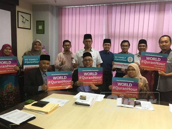 Mufti Melaka, Datuk Abdul Halim Tawil (duduk, kiri) menampilkan poster World #QuranHour