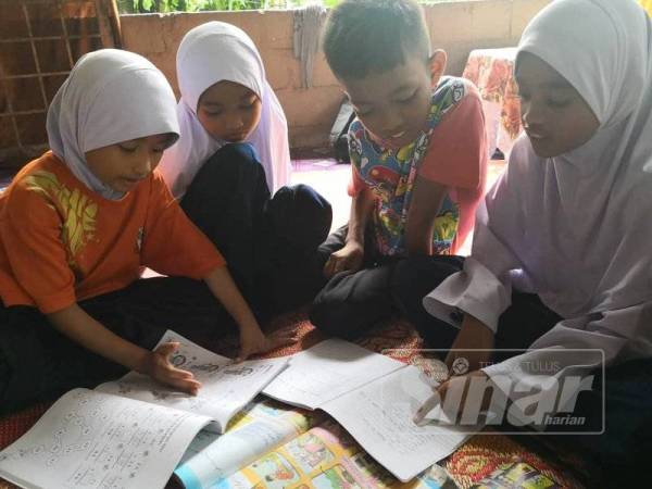 Muhammad Aiman Syazwan membantu adik-adiknya mengulangkaji pelajaran.