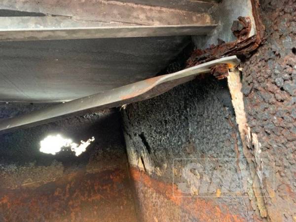 Tangki air yang berkarat dan berlubang.