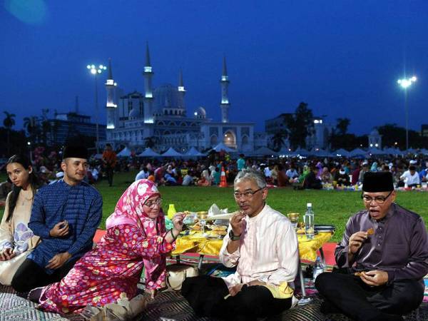 Yang di-Pertuan Agong Al-Sultan Abdullah Ri'ayatuddin Al-Mustafa Billah Shah dan Raja Permaisuri Agong Tunku Azizah Aminah Maimunah Iskandariah tertarik dengan juadah yang dijual peniaga Bazar Ramadan Taman Kerang hari ini. - Foto Bernama