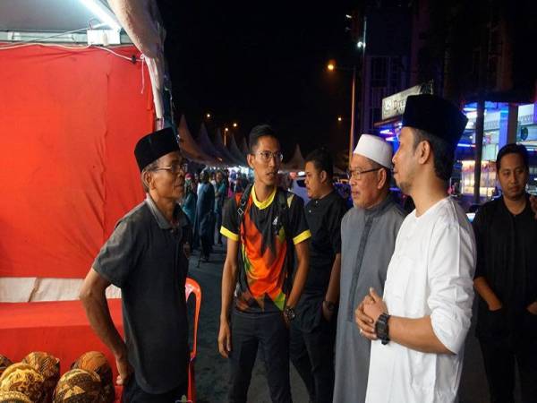 Mohamad Sukry (dua dari kanan) melawat Bazar Raya di Pusat Perniagaan Wawasan Simpang Renggam malam kelmarin. FOTO: MDSRt