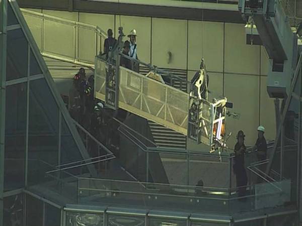 Dua pencuci tingkap yang berada di puncak Menara Devon setinggi 50 tingkat berdepan detik cemas.
