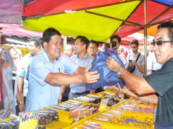 Loy Sian menyampaikan cenderamata kepada peniaga pada program Bazar Ramadan Mampan dan Kempen Amalan Hijau dengan kerjasama Majlis Perbandaran Selayang (MPS) di Taman Greenwood, di sini semalam.