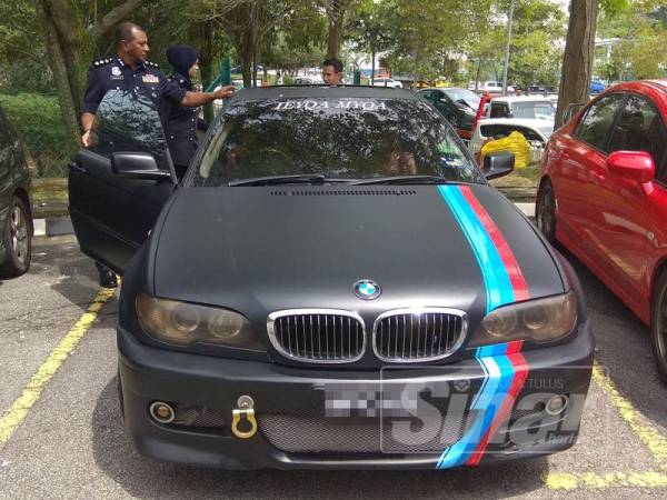 Baharudin (kiri) melihat kereta BMW 5 series milik pasangan kekasih yang dirampas dalam serbuan semalam.