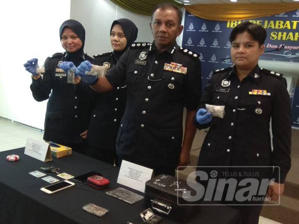 Baharudin (dua,kanan) menunjukkan dadah syabu dan ganja bernilai RM50,000 yang dirampas dalam dua serbuan di sebuah hotel bajet di Pusat Komersial Seksyen 7, di sini, semalam.