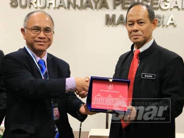 Naib Canselor KUIM, Prof Dr Md Radzai Said menyampaikan cenderamata kepada Ketua Pesuruhjaya SPRM, Datuk Seri Mohd Shukri Abdull.