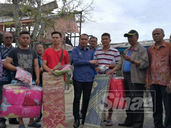 Abdul Yunus (tengah) menyerahkan sumbangan wang tunai dan barangan keperluan harian daripada kerajaan Perak dan Jabatan Kebajikan Masyarakat (JKM) kepada Kean Yeah (dua dari kanan) dan dua wakil keluarga mangsa kebakaran lain di Bagan Seberang hari ini.