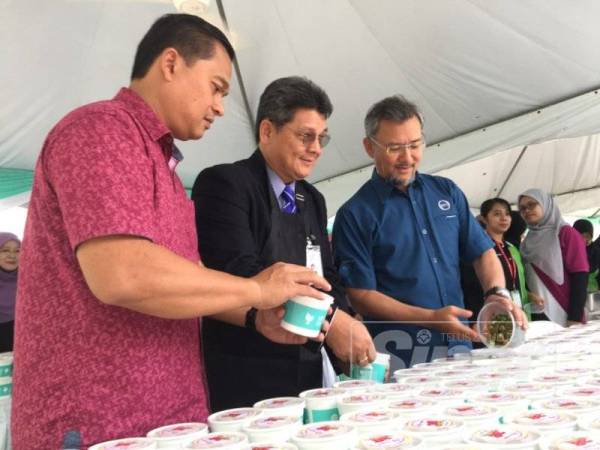 Amiruddin (kanan) bersama Mohamad Fauzi (kiri) ketika merasmian bubur lambuk amal.