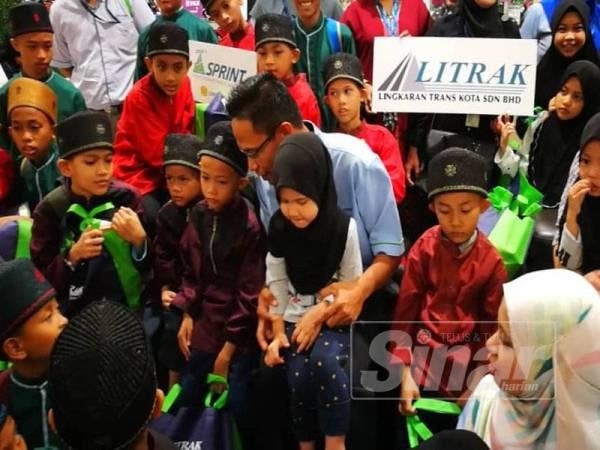 Shah Rizal bertanya sesuatu kepada kanak-kanak dari Pusat Jagaan Telaga Kasih Nur Muhammad, Kota Damansara selepas program membeli keperluan raya di Aeon Mall, Shah Alam di sini.