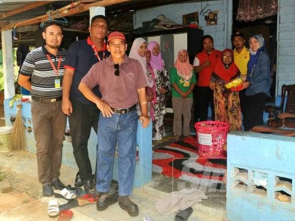 Misnah (tiga dari kanan) menerima sumbangan daripada Risda Batu Pahat di rumahnya di Tongkang Pechah semalam.