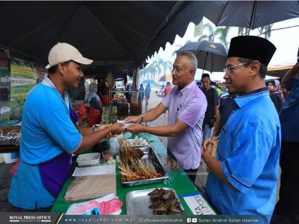 Pegawai Daerah Mersing, Asman Shah Abd Rahman sebagai wakil rakyat Sultan Johor menyampaikan kurniaan sumbangan kepada peniaga. - Foto Royal Press Office