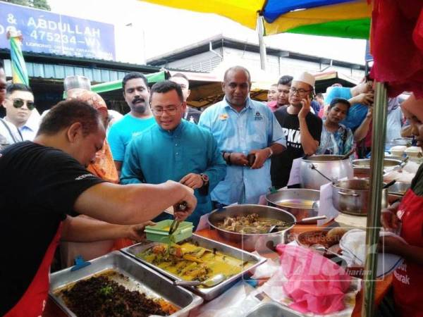 Amirudin membeli juadah berbuka puasa dengan membawa bekas makanan sendiri sebagai kempen tiada penggunaan plastik di Selangor sewaktu turun padang di bazar Ramadan, Selayang Baru, petang tadi.
