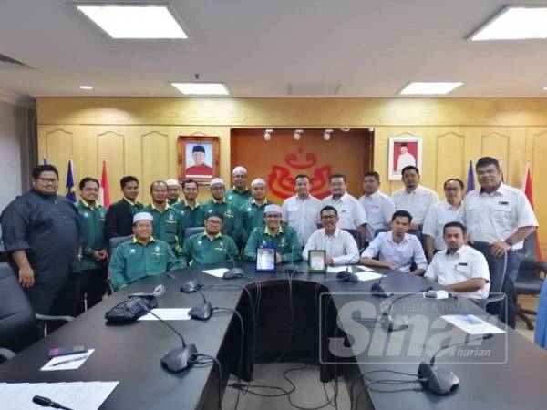 Nurul Amin (duduk, tiga kiri) dan Mohd Fadzil (duduk, tiga kanan) bergambar bersama seluruh ahli jawatankuasa Pemuda Pas dan Pemuda UMNO Kedah selepas pertemuan rasmi pertama di Pejabat Pemuda UMNO Kedah di Alor Setar, semalam.