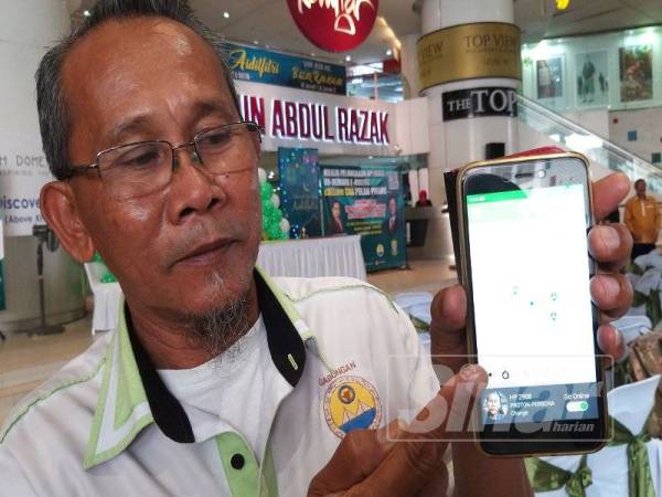 Nor Fadil menunjukkan aplikasi cALLme Cab yang digunakan oleh 500 pemandu teksi di negeri ini.