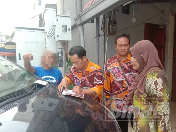 Anggota penguat kuasa mengeluarkan notis tidak menghormati Ramadan kepada seorang warga emas (kiri).