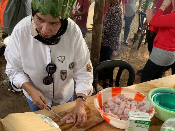 Salah seorang sukarelawan menyediakan hidangan bubur lambuk ketika Program Jiwa Murni Majlis Iftar Ramadan bersama Masyarakat Orang Asli Kg Jeram Padang, Bahau Negeri Sembilan. 