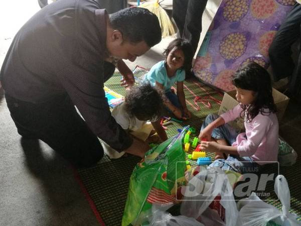 Pengurus Econsave Wilayah Utara, Zamzuri Mansor melayani telatah anak-anak Mohd Ridzuan.