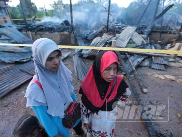 Fatma (kiri) dan Khadijah hanya mampu berputih mata melihat rumah sewa mereka musnah dalam kebakaran.