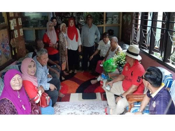 Mohd Rafiq (tengah) ketika menyantuni rumah seorang penduduk di Kampung Lanjut Manis, Krubong, di sini hari ini.