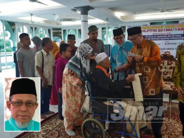 Dr. Shahruddin menyampaikan sumbangan kepada penerima OKU. (Gambar kecil: Zakariah)