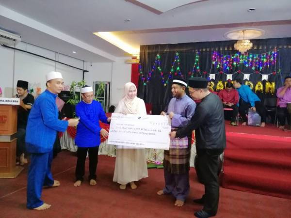 Tina menyerahkan kutipan yang dibuat kepada Pengurus Aman Palestin Perak, Khairul Amin Ibrahim.