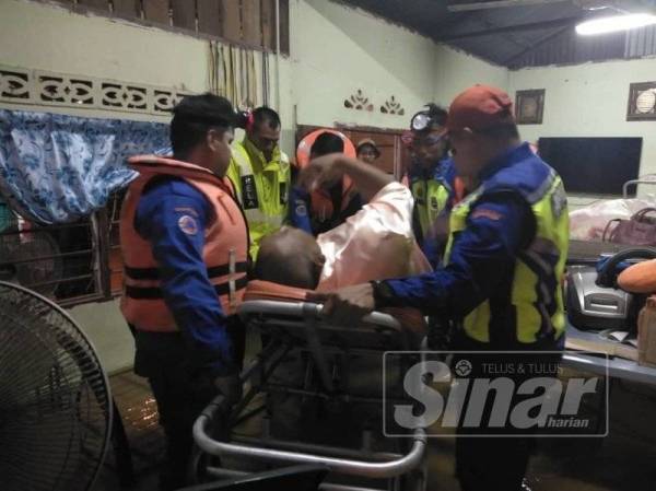 JPAM membantu membawa mangsa banjir kilat untuk dipindahkan ke Masjid Sungai Bayor, semalam.