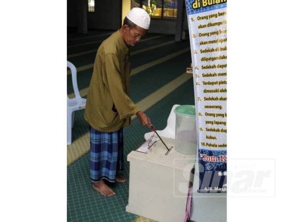Daud menunjukkan tabung masjid berkenaan. 