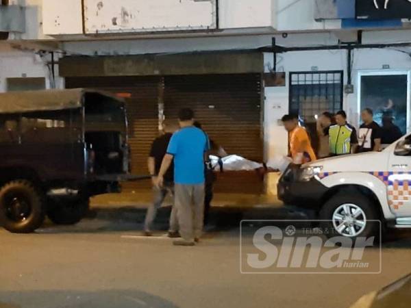 Anggota polis mengangkat mayat wanita warga Myanmar yang ditemui tergantung di Bandar Baru Medan Ipoh, hari ini.