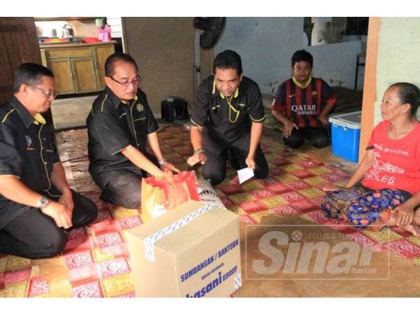 Shaharom Nizam (dua dari kiri) menyerahkan sumbangan kepada seorang penerima di Kampung Limbong Kapal, di sini tadi.