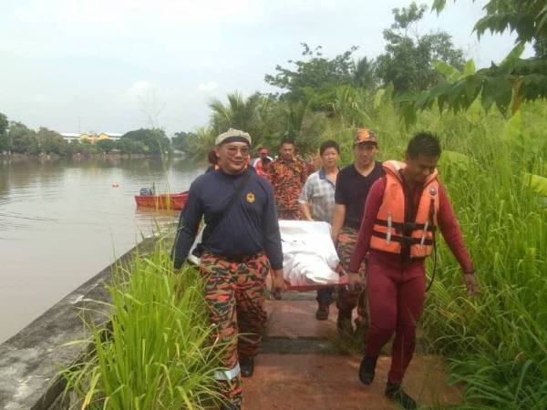 Beberapa anggota bomba mengusung mayat mangsa ditemui kira-kira jam 10.21 pagi di Sungai Kedah, di sini, hari ini. - FOTO IHSAN JBPM