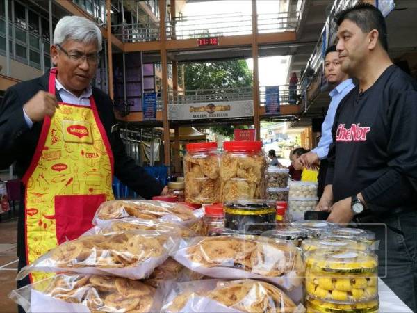 Abdul Aziz melihat kuih raya yang turut dijual sempena Program Gotong Royong Bubur Lambuk Peringkat JPN Perak di Atrium Gemilang JPN.