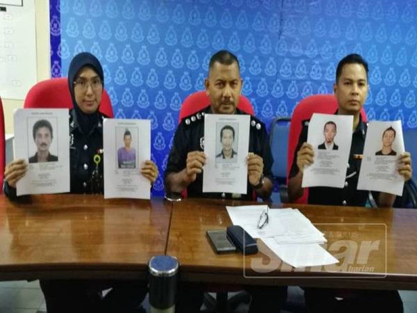 Razmi (tengah) bersama pegawainya menunjukkan wajah individu yang diburu di Pejabat IPK Terengganu, di sini hari ini.