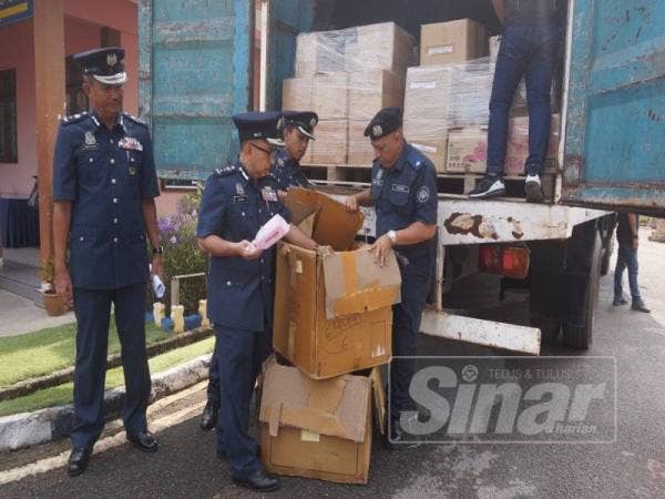 Johari (tengah) menunjukkan kotak terpakai barangan runcit digunakan untuk mengaburi mata pihak berkuasa di JKDM, Jalan Pegawai, di sini hari ini.