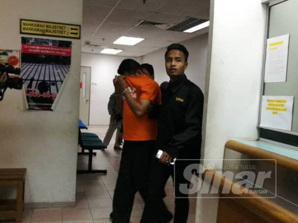 Suspek diiringi pegawai SPRM ketika hadir ke mahkamah hari ini.