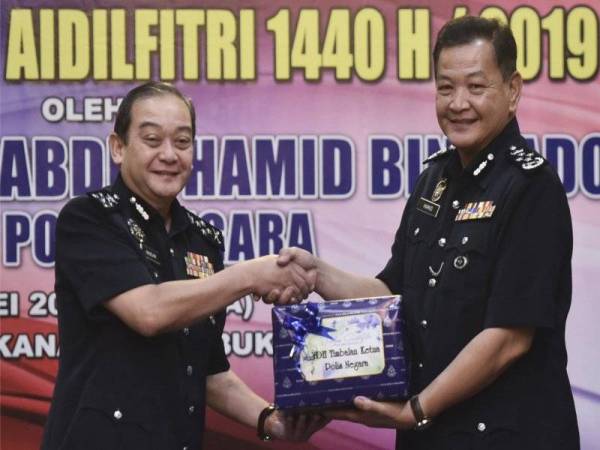 Ketua Polis Negara Datuk Seri Abdul Hamid Bador (kanan) menyerahkan bungkusan kuih raya kepada timbalannya Datuk Mazlan Mansor pada Majlis Penyerahan Bungkusan Kuih Raya Polis Diraja Malaysia sempena Hari Raya Aidilfitri di Ibu Pejabat Polis Bukit Aman hari ini. - Foto Bernama

