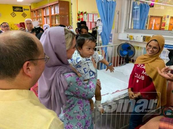 Cik Puan Sofie memangku Al Iman semasa kunjungan tersebut.