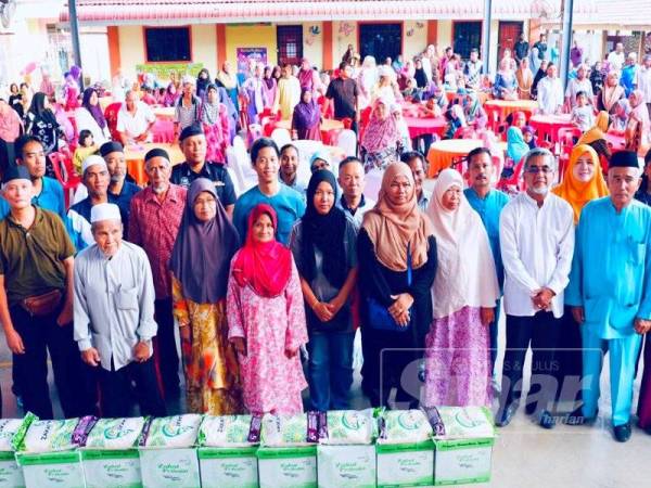 Hsiao Leung bergambar bersama sebahagian penerima bantuan pada Majlis Iftar Sinari Kampungku kelmarin.