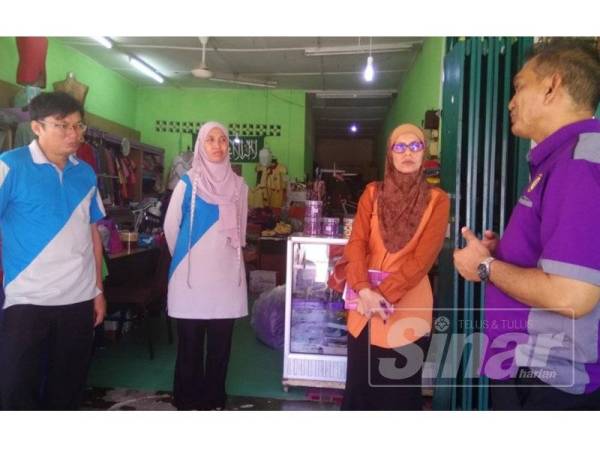 Auf (kiri) dan Mah (dua dari kiri) ketika menerima kehadiran wakil Zakat Melaka di kedainya di Sungai Udang.