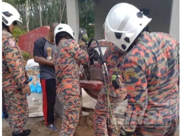 Anggota bomba Gerik menjalankan operasi mengeluarkan tangan mangsa yang tersepit pada mesin pembancuh simen, hari ini.