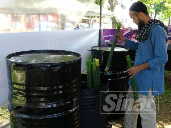 Nik Suhaimy menyusun lemang ke dalam tong dram untuk dimasak.