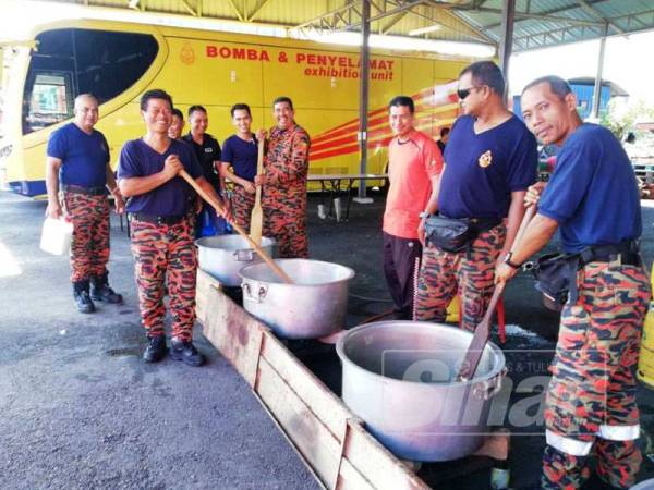 Anggota bomba memasak bubur lambuk beramai-ramai sebelum diagihkan kepada orang ramai.