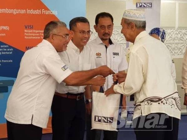 Fahmi (dua dari kiri) menyampaikan sumbangan kepada asnaf di Masjid Ar-Rahah Kampung Kerinchi.