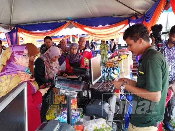 Pembeli beratur untuk menjelaskan bayaran di Karnival Jimat Belanja di Masjid Ar-Rahah Kampung Kerinchi yang berlangsung selama tiga hari
bermula hari ini.