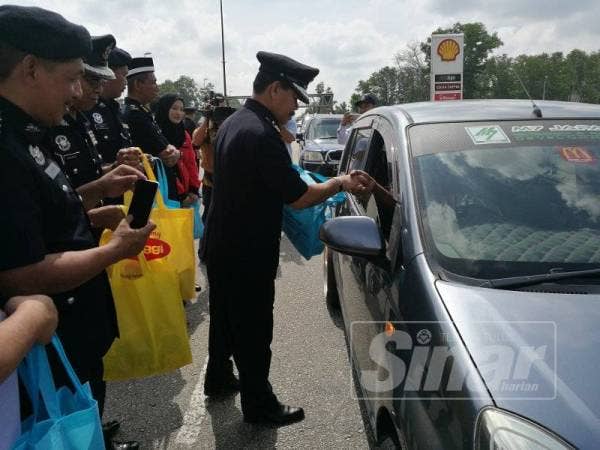 Othman mengagihkan goodies kepada pengguna Jalan Pintasan Kuantan sempena Pelancaran Ops Selamat 15