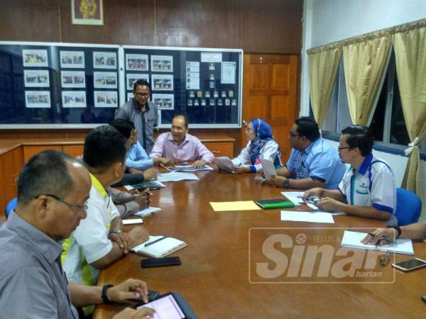 Izham (empat dari kanan) berbincang bersama pihak berkaitan sebelum melakukan lawatan tapak di sekitar kawasan Meru, hari ini.