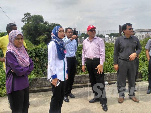 Izham (dua dari kanan) meninjau salah satu lokasi yang menjadi punca banjir di kawasan Meru sejak beberapa tahun lalu.